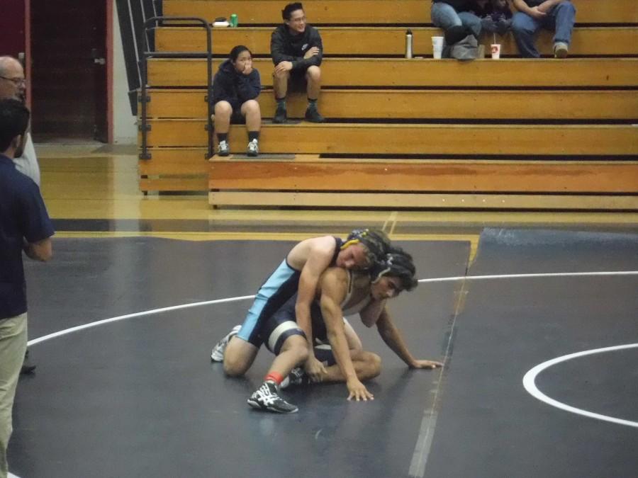 UC Wrestler Skylar Phillips works to pin a Hoover High opponent.