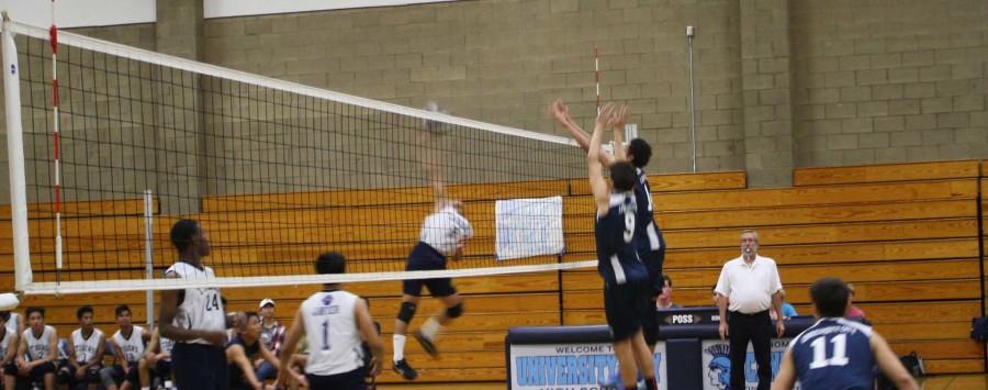 Junior Skylar Tylski and Senior Corey Goldstin jump towards the net to block a spike.