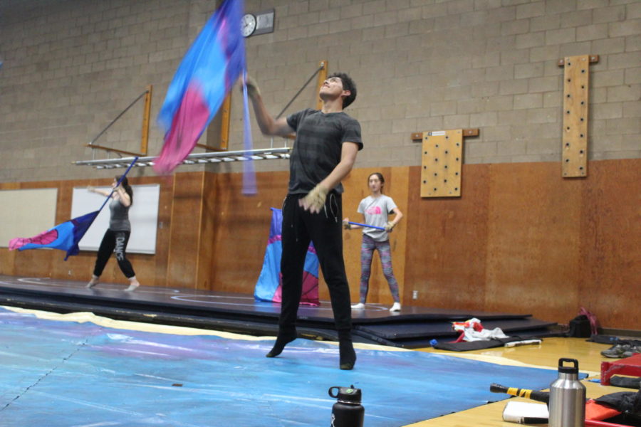 Senior Alex Aguilar twirls a flag at practice.