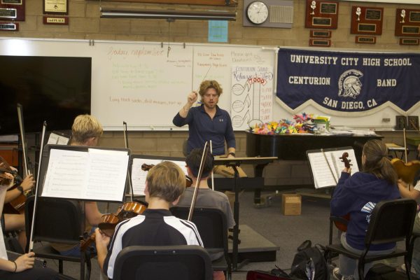 New Music Department Director Brandon Rhinehart enthusiastically UC Highs orchestra.