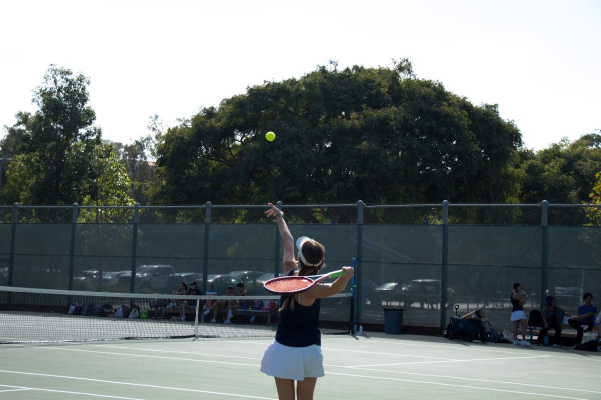 Senior Maria Lapikova mid-serve during a match.