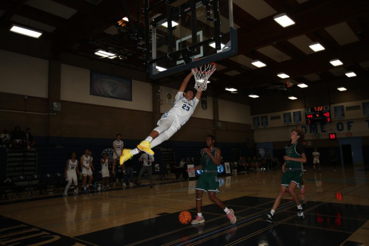Junior Dylan Griffin making a dunk at the home opener game against Helix Charter.