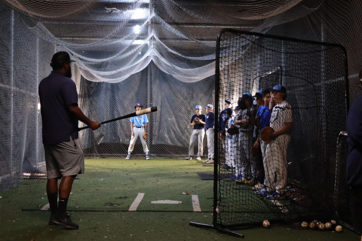 Coach+Chris+Greer+in+the+batting+cage+instructing+the+prep+baseball+team.