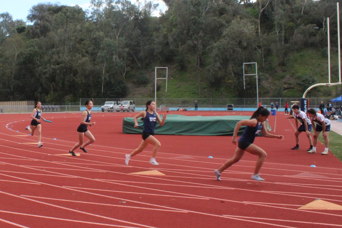 UC High's girls competing in a 4x100 meter relay race during a track meet.
